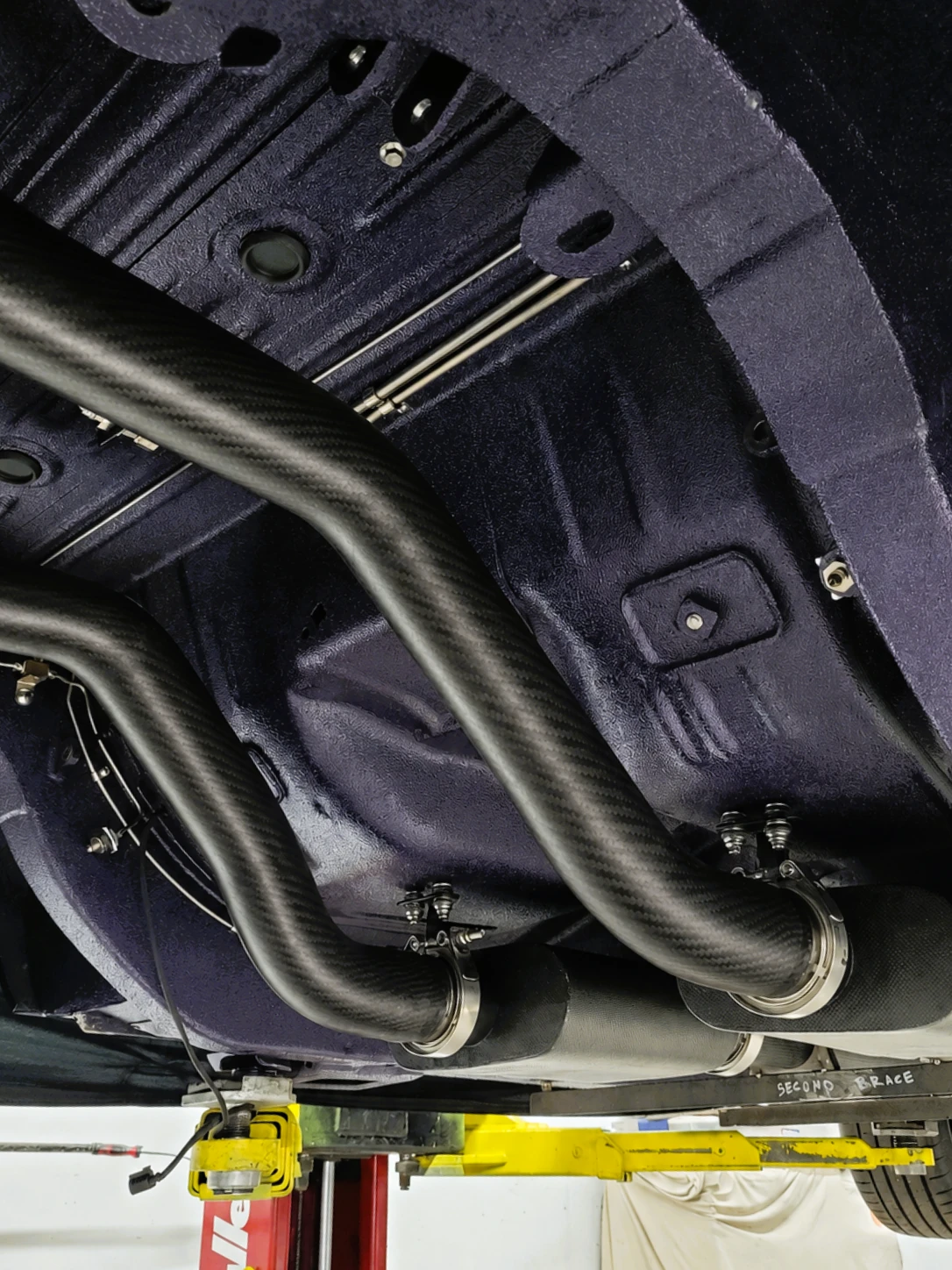 Close view of the carbon fiber exhaust routing under Haraka